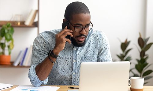 Man on phone with laptop