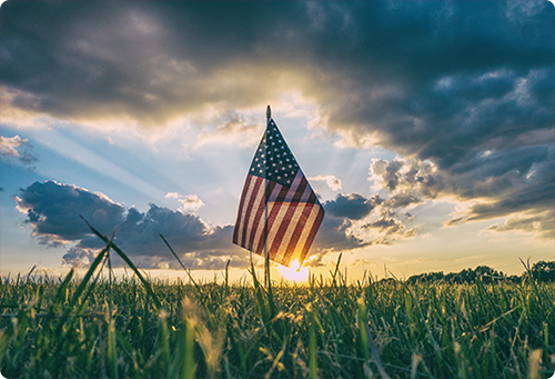 American flag waving in a grass field American flag waving in a grass field